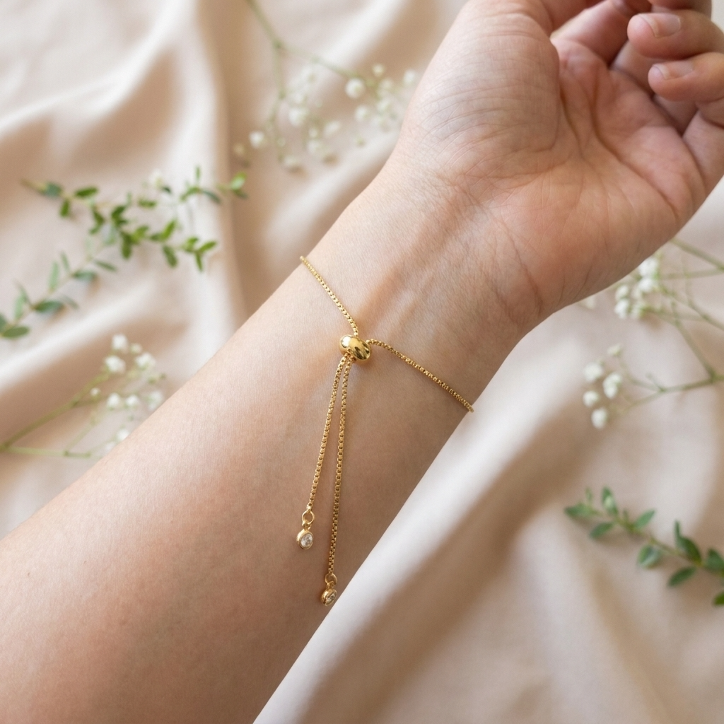 Close-up of the adjustable slider mechanism on a gold plated daisy bracelet, showing the bracelet fastening and fit detail