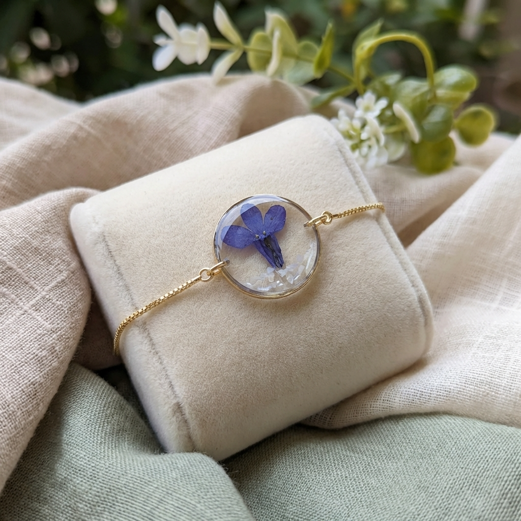 Blue lobelia 20mm flat bracelet with seashell flakes on jewelry display stand, handmade real flower jewelry by Work by Nature
