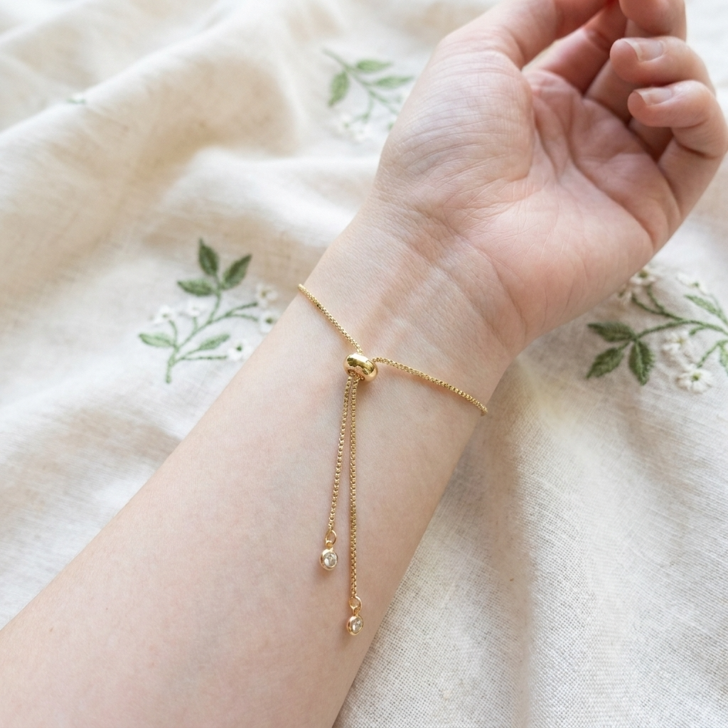 Close-up of the adjustable slider mechanism on a gold plated daisy bracelet, showing the bracelet fastening and fit detail