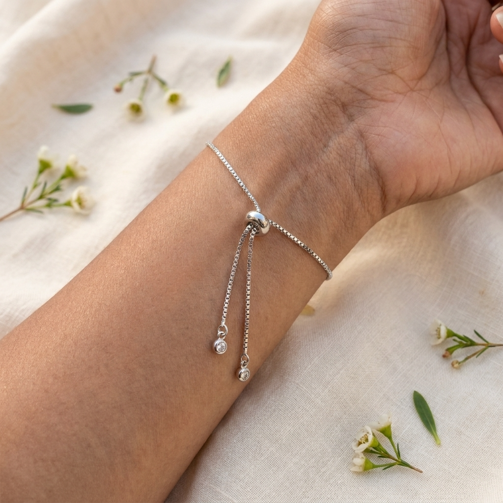 Close-up of the adjustable slider mechanism on a platinum plated daisy bracelet, showing the bracelet fastening and fit detail