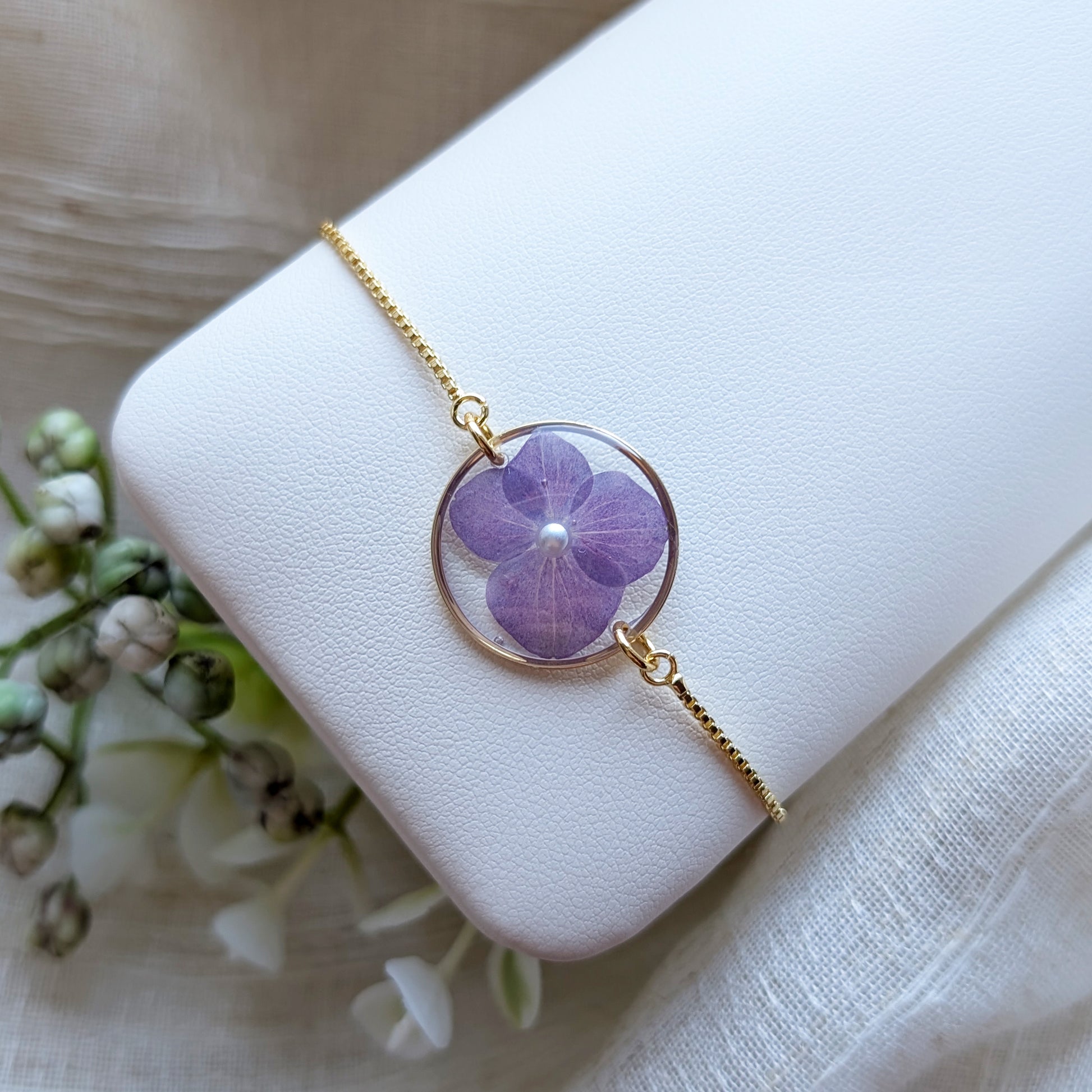 Purple hydrangea 20mm flat bracelet with imitation pearl on jewelry display stand, handmade real flower jewelry by Work by Nature