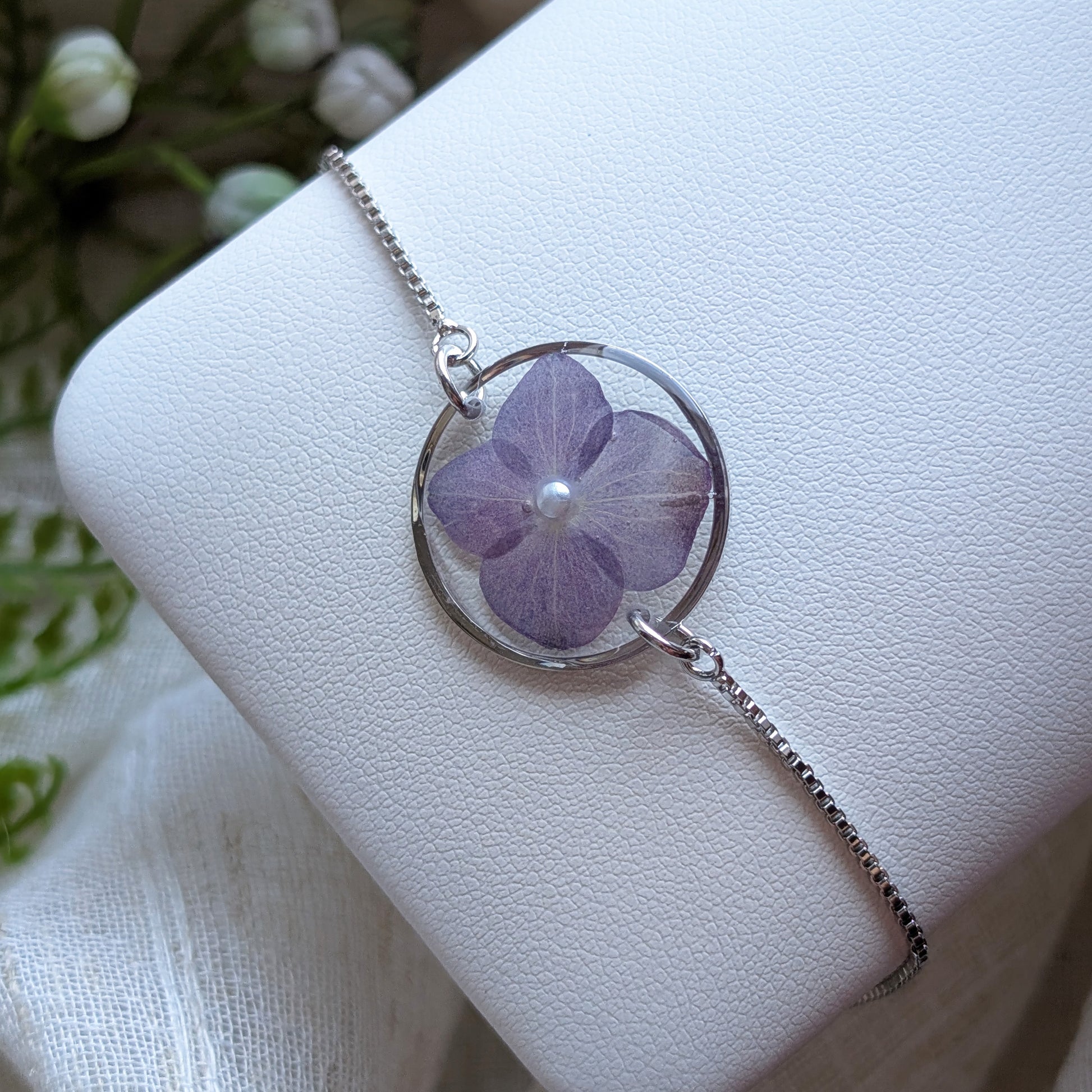 Purple hydrangea 20mm flat bracelet with imitation pearl on jewellery display stand, handmade real flower jewellery by Work by Nature