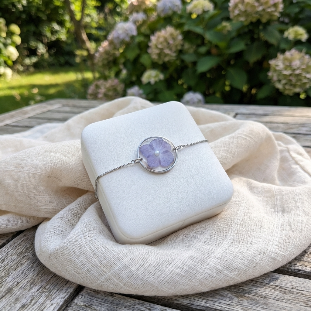 Platinum plated purple hydrangea bracelet shown on a jewellery holder, crafted with real flowers, resin and an imitation pearl centre