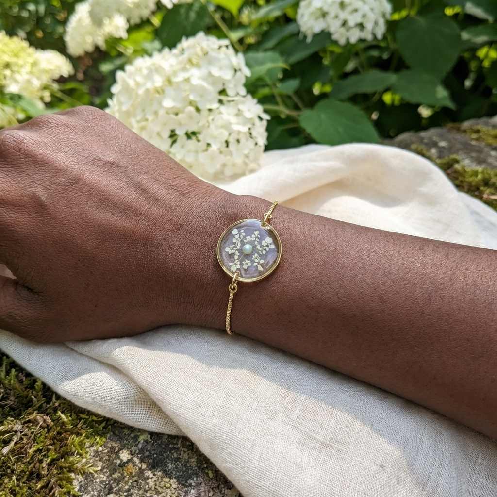 Dark skin tone model wearing a Queen Anne’s Lace bracelet, showing a soft contrast with delicate gold plated jewellery