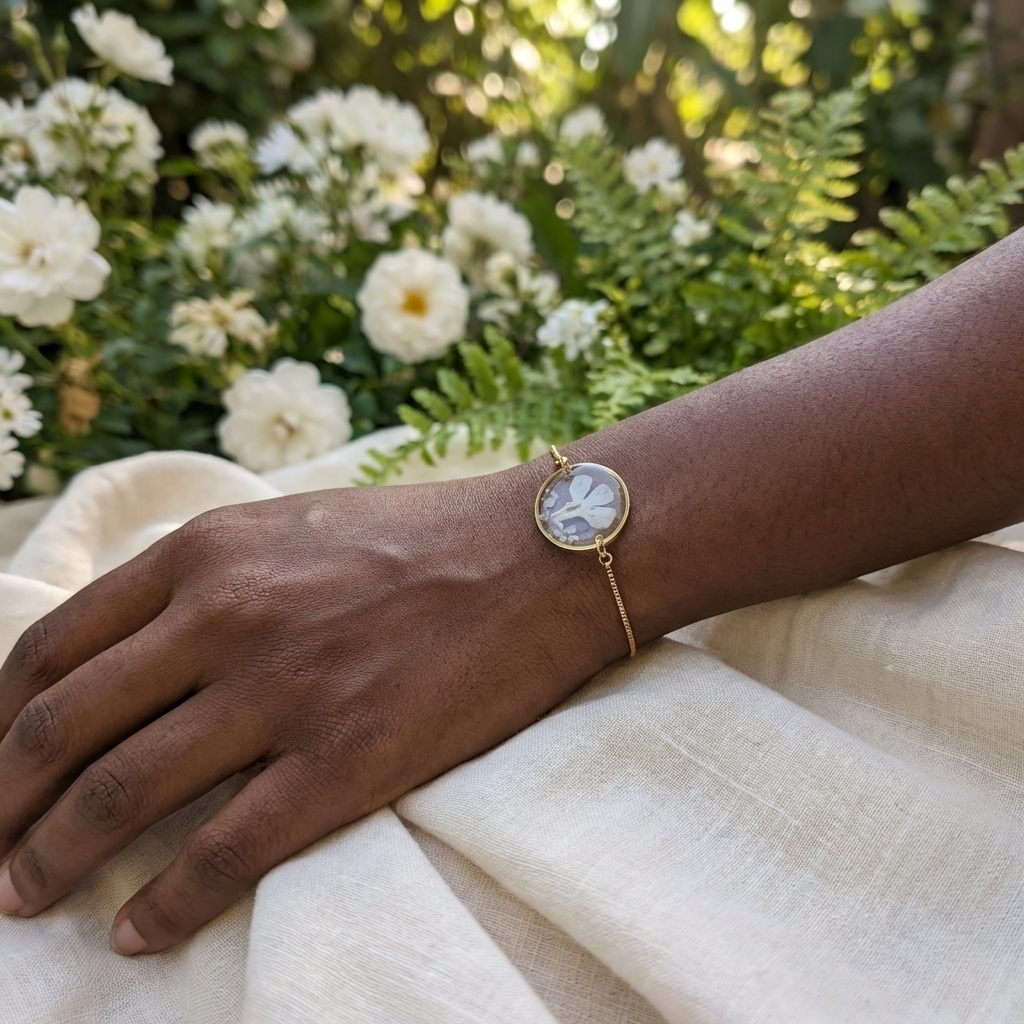 Dark skin tone model wearing a white lobelia bracelet, showing a soft contrast with delicate gold plated jewellery