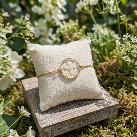 White lobelia 20mm flat bracelet with seashell flakes on jewellery display stand, handmade real flower jewellery by Work by Nature