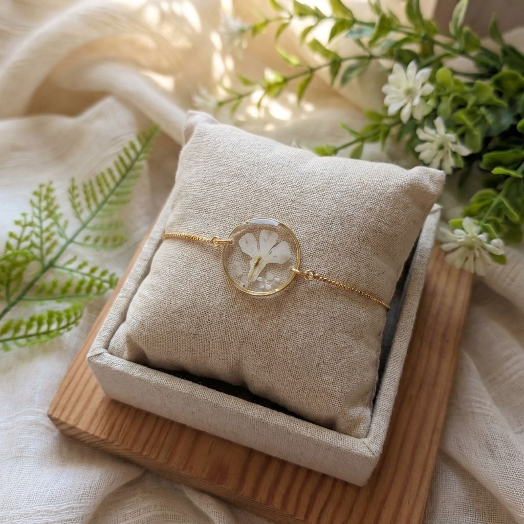 White lobelia 20mm flat bracelet with seashell flakes on jewelry display stand, handmade real flower jewelry by Work by Nature